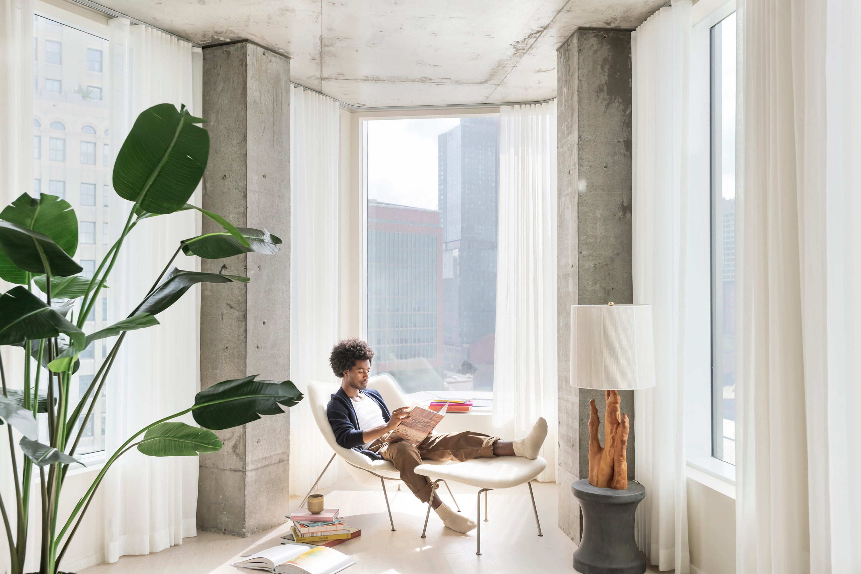 Modern apartment interior with concrete pillars and floor-to-ceiling city views